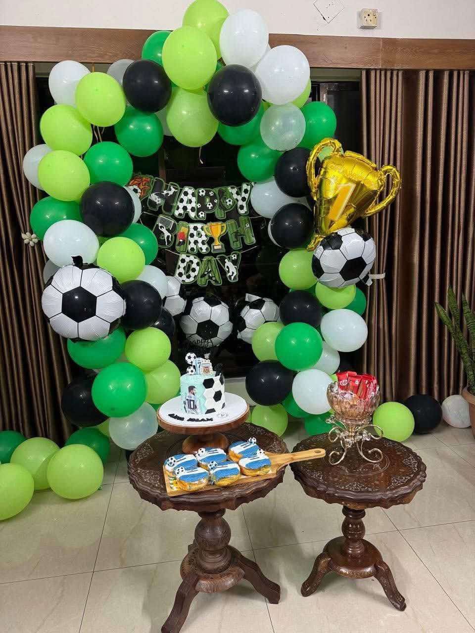 Football themed green, black and white balloon garland with party table